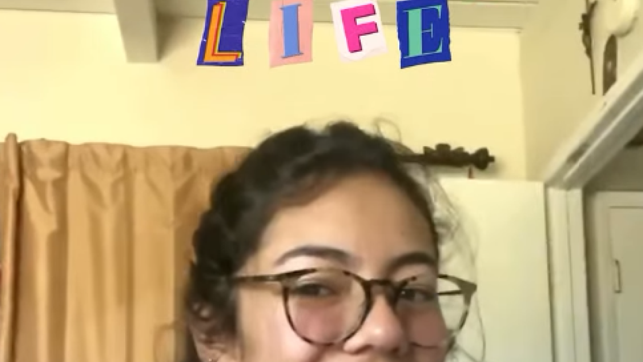 Girl in her bedroom waving