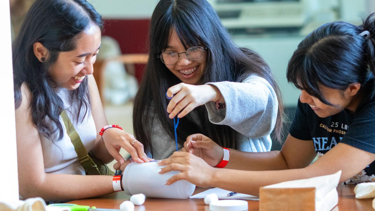 three students practice design, communication and teamwork in the annual Engineering Dean's Undergraduate Challenge at UC Davis.