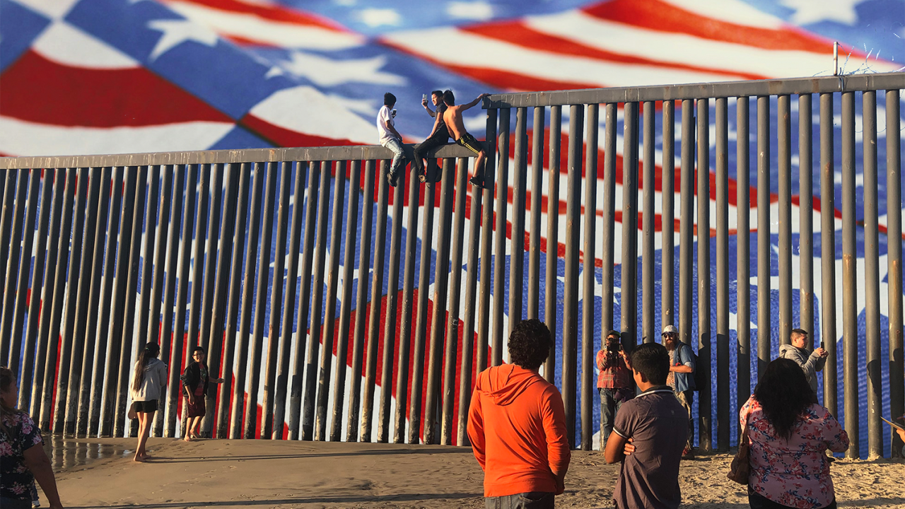 People pose for photos at the Mexico/U.S. border wall.