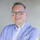 Man in glasses and a pale blue suit