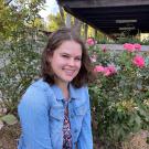 Woman in blue shirt seated in front of roses